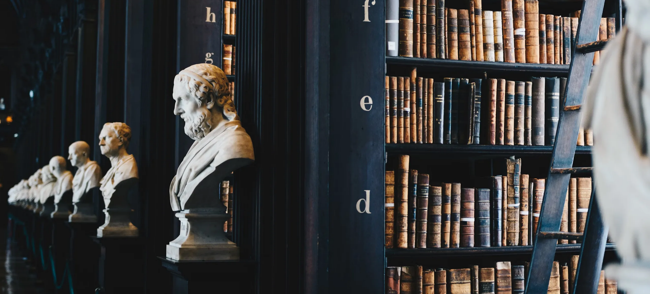 Two women sitting at a modern table talking with a city view behind them.